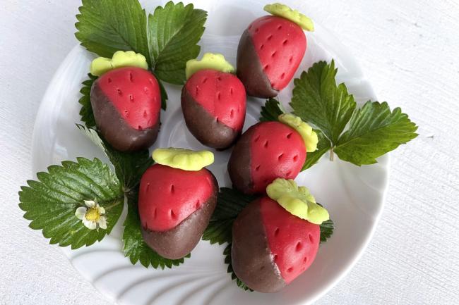 Marzipan Erdbeeren, verziert mit Glücksklee und in Schokolade getunkt